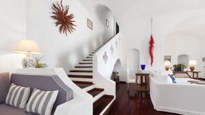 A modern living room with a staircase, white sofas, and a wooden floor. - La Villa, luxury villa with private sea access (Campania)