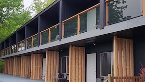 A modern building with a flat roof, large windows, and a wooden deck.