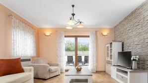 Un salon moderne comprenant un canapé, des fauteuils, une table basse et un meuble pour la télévision.