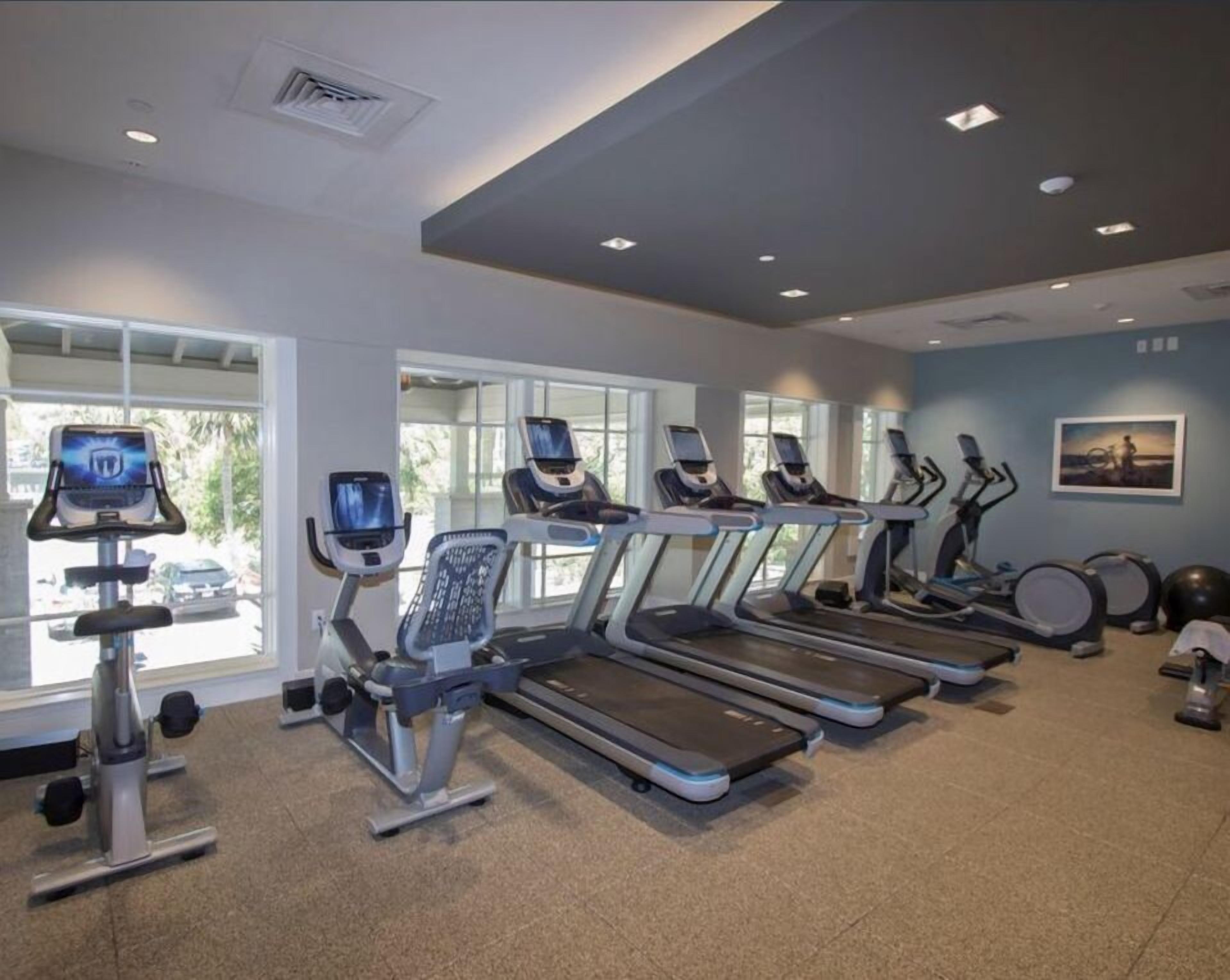 A gym with treadmills, stationary bikes, and weights.