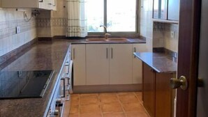 Uma cozinha compacta com janela, forno embutido e pia.