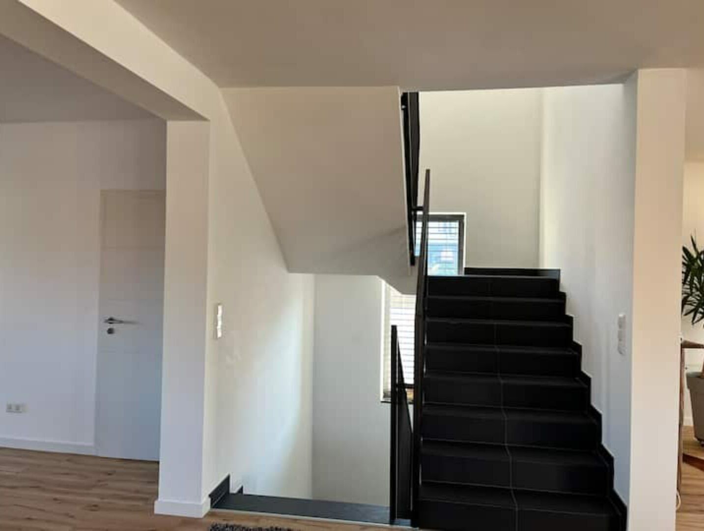 A staircase with black steps leading to an upper floor.