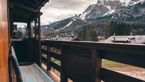 A wooden deck with a bench, overlooking a mountainous landscape with snow-capped peaks and a cloudy sky. - Casa Ca Dei Pini, surrounded by Nature (Cortina d´Ampezzo)