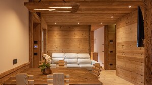 A wooden interior with a dining table, chairs, and a sofa. - Casa Ca Dei Pini, surrounded by Nature (Cortina d´Ampezzo)