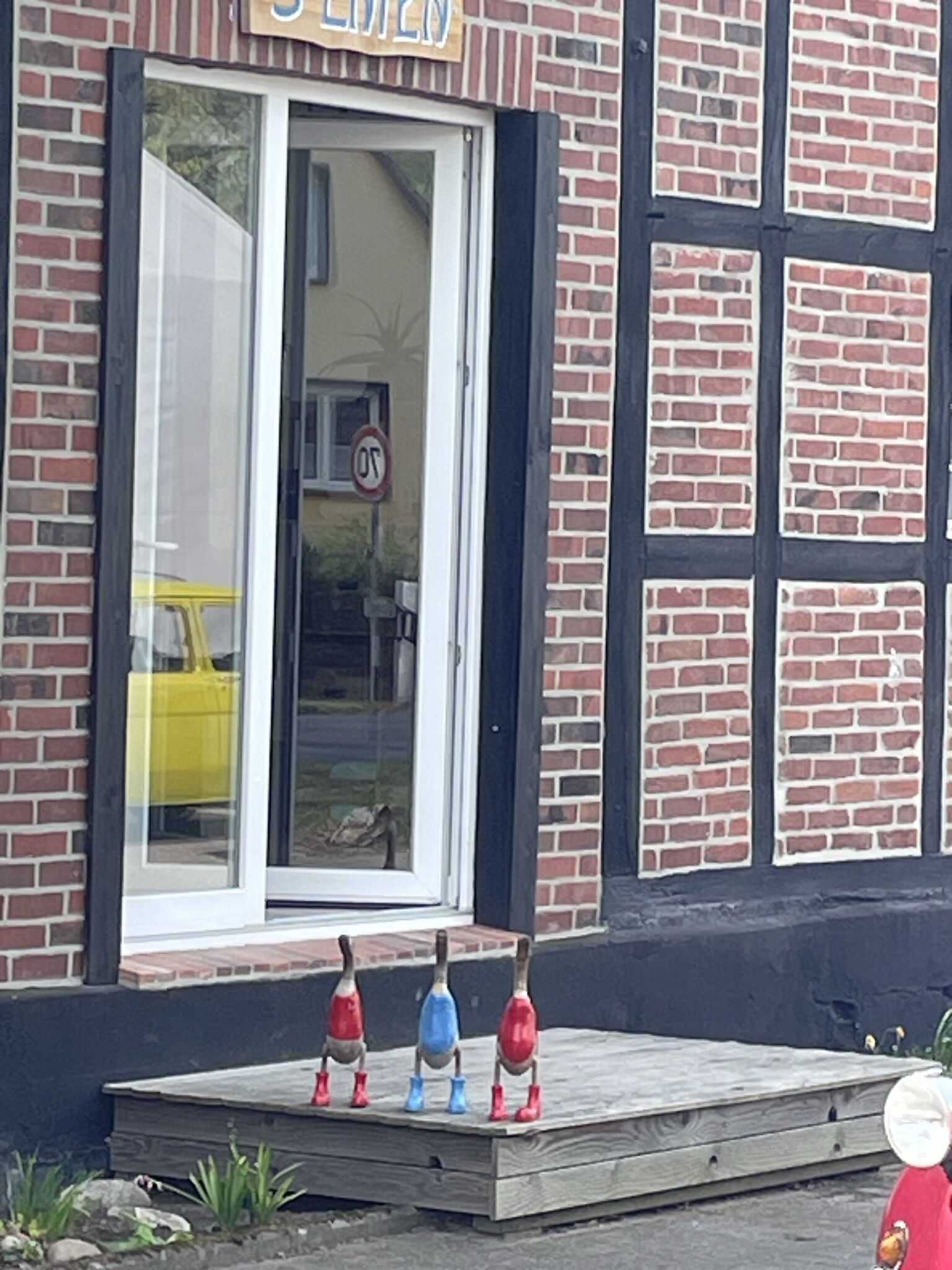 A brick building with a large window and a sign above it.