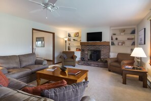 A living room with a fireplace, sofas, and a television.