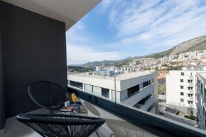 A balcony with a view of a cityscape, including buildings and a mountain. - City Residences (Dubrovnik)