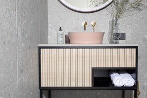 A bathroom vanity with a pink sink, a mirror, and a towel rack. - Bob W Bonn Zentrum (Bonn)