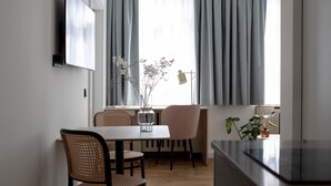 A modern dining area with a table, chairs, and a TV mounted on the wall. - Bob W Bonn Zentrum (Bonn)