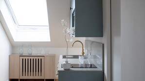 A compact kitchen with a skylight, a wooden cabinet, and a sink. - Bob W Bonn Zentrum (Bonn)