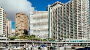 A waterfront hotel with multiple high-rise buildings, a marina with boats, and a clear blue sky. - Tropical City Escape at Ilikai Hotel by the Beach w/Great Building Amenities (Honolulu)