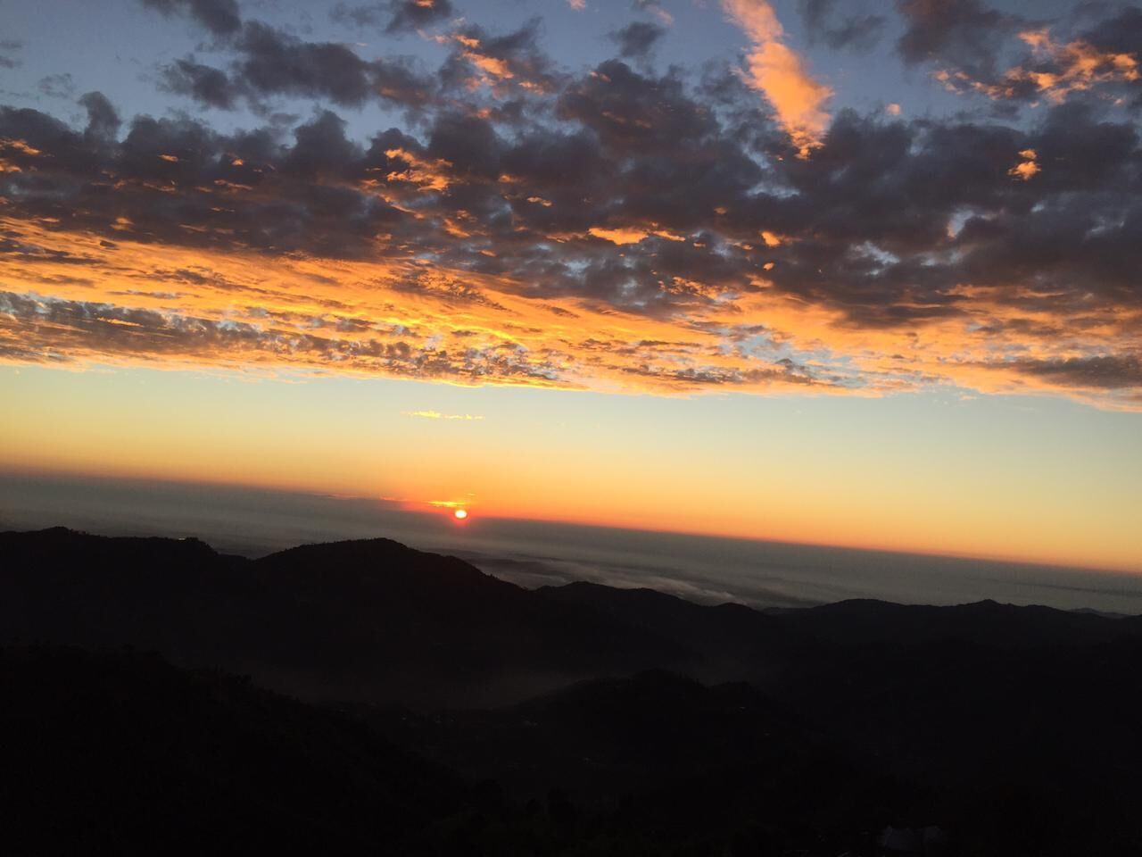 A sunset over a mountainous landscape.