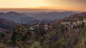 A mountainous landscape with scattered buildings and a clear sky. - The Bryll Homes (Krishangarh)