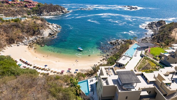 Un hôtel situé sur la côte, doté d’une piscine, d’un accès à la plage et offrant une vue sur l’océan.