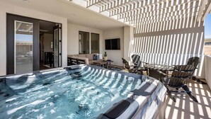 A rooftop pool area with a hot tub, outdoor seating, and a pergola providing shade. - The Jolly Roger: Desert Color Lagoon + Beaches (St. George)