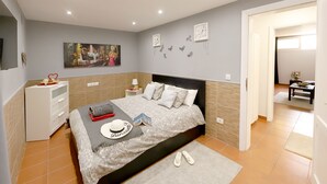 Un dormitorio con cama, mesitas de noche, cómoda y un cuadro en la pared.