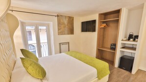 A bedroom with a bed, a radiator, a wardrobe, and a coffee machine. - Grottini Luxury Suites - Pantheon (Rome)