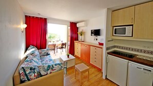 A compact living space with a sofa, dining table, and kitchenette. - Apartment Cap Esterel sea view with reversible air conditioning (Saint-Raphaël)