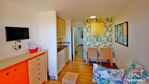 A compact living space with a kitchenette, a dining area, and a sofa. - Apartment Cap Esterel sea view with reversible air conditioning (Saint-Raphaël)