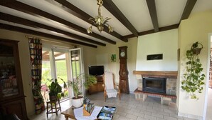 A living room with a fireplace, a television, and a large window.
