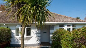 Einbungalow mit Ziegeldach, einer Haustür und einer kleinen Veranda.
