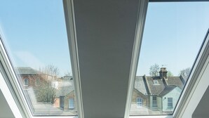 Ein Dachfenster mit Blick auf angrenzende Häuser.