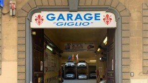 An entrance to a garage named "GIGLIO" with a stone facade and a sign above the door. - VRooms All'Angolo Del Duomo (Florence)