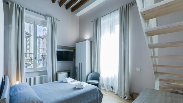 A modern hotel room with a bed, a TV, a desk, and a chair. - VRooms All'Angolo Del Duomo (Florence)