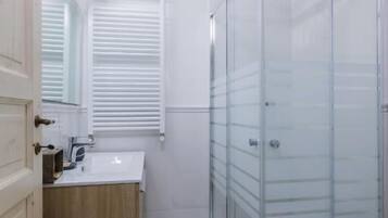 Comfort vierpersoonskamer | Badkamer | Een douche, gratis toiletartikelen, een haardroger, handdoeken