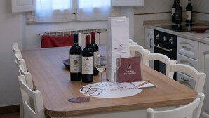 Una mesa de comedor con botellas de vino, copas y una carta.