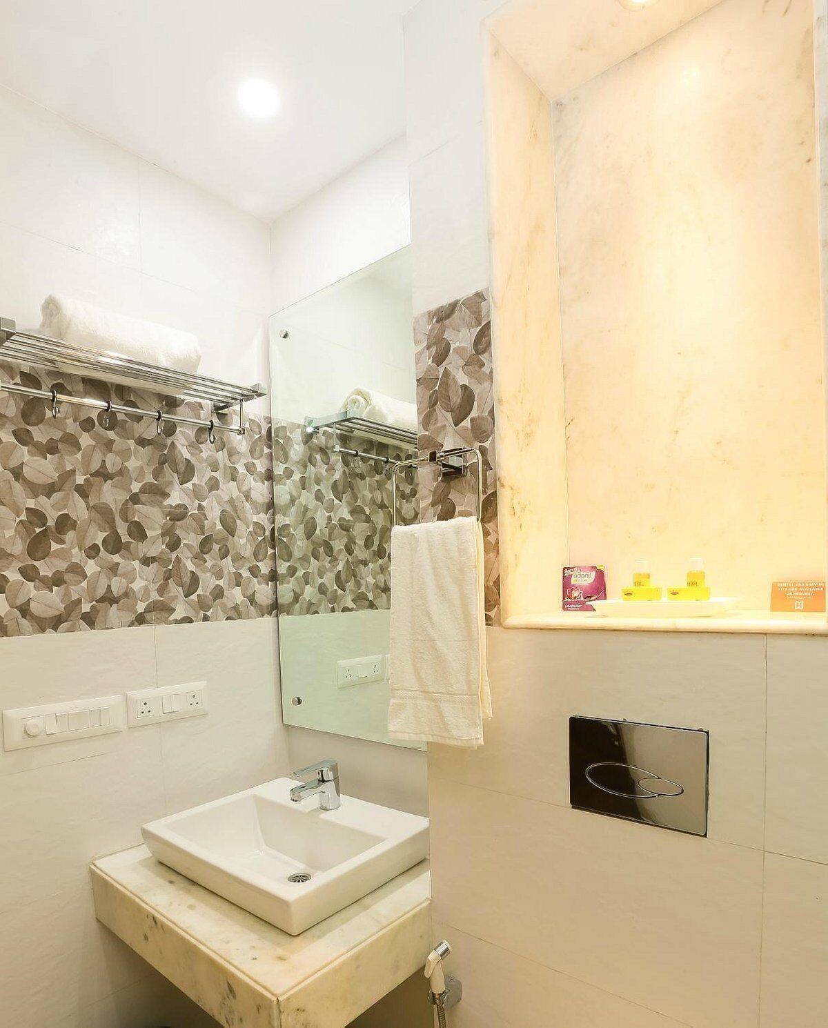A modern bathroom with a large mirror, a sink, and a shower area.