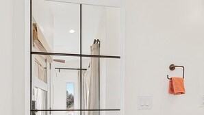 Een kamer met een spiegelkast, een houten plank en een handdoekhouder.