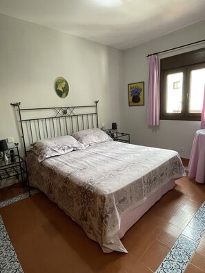 A bedroom with a bed, a bedside table, a lamp, a wall clock, and a window with curtains. - Lovely holiday home located in the desirable area of Marbella, (Marbella)