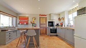 A modern kitchen with grey cabinets, a wooden island, and a 'Cuisine' sign on the wall.