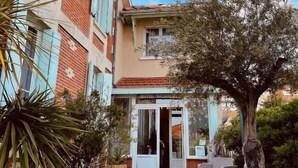 A hotel with a brick facade, a central entrance, and outdoor seating. - Hôtel Michelet Plage (Soulac-sur-Mer)