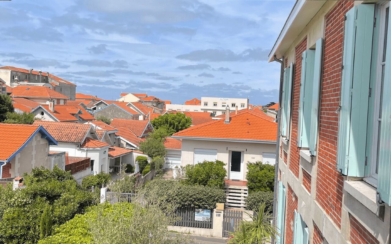 A residential area with red-tiled roofs, white buildings, and green shutters.