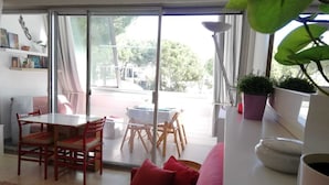 Una sala de estar luminosa con un puerta corrediza de vidrio que da a un patio exterior.