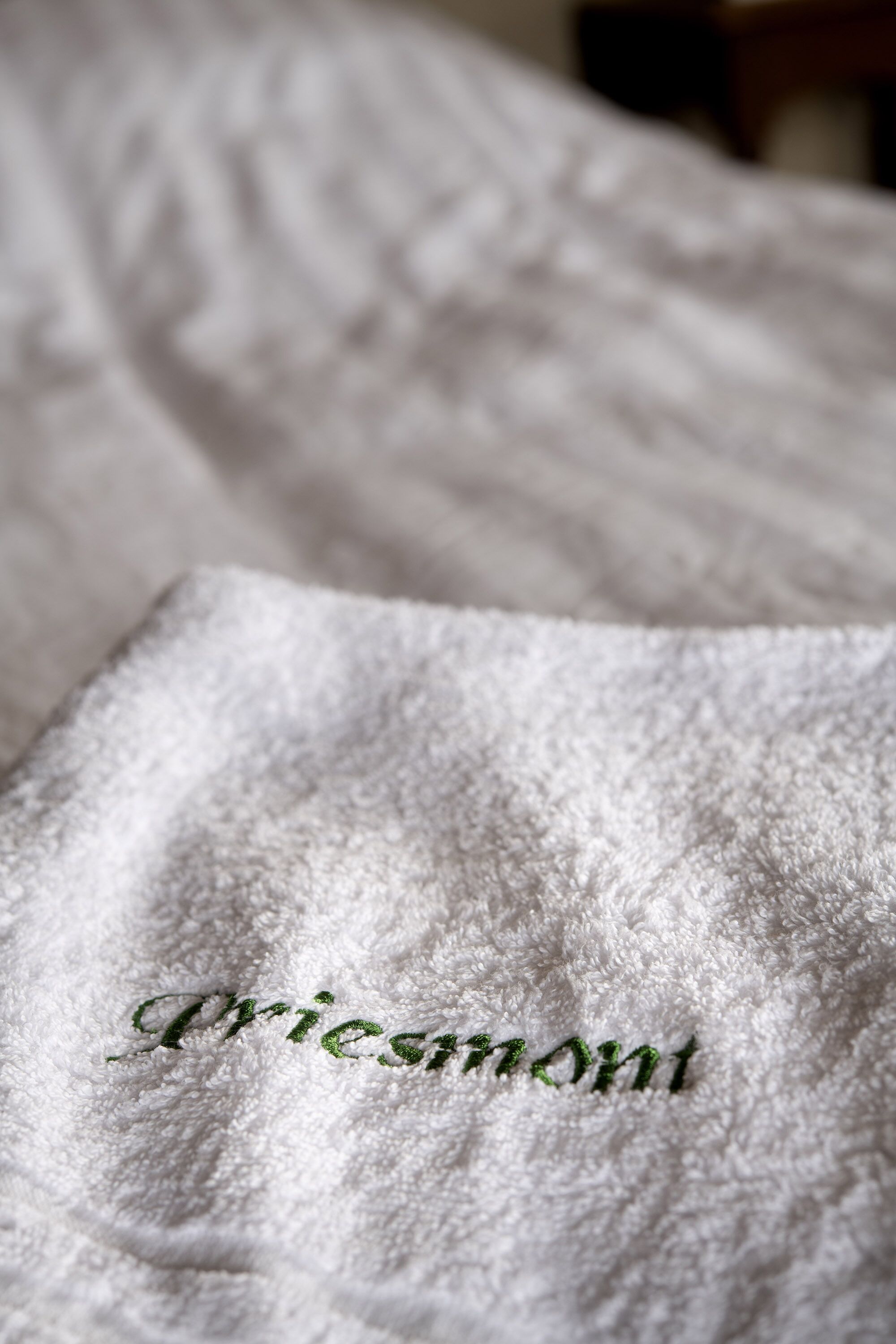 A white textured fabric with embroidered text.