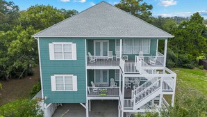 A two-story house with a balcony and a sign advertising a hockey rink. - Antigua Blue - Private Pool - Walk to Beach - 6BR/7BA (North Myrtle Beach)