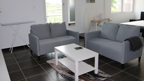 En moderne stue med to grå sofaer, et hvidt sofabord og et lille sofabord.
