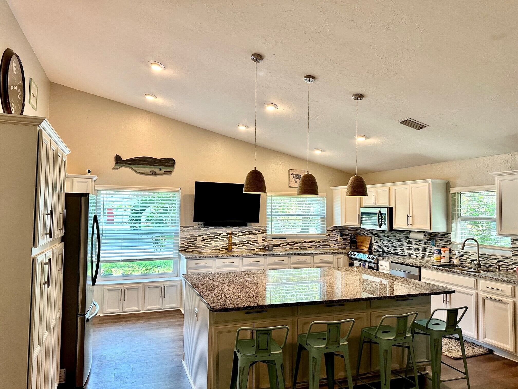 Kitchen with a giant island and seating for four. Cooking essentials are stocked