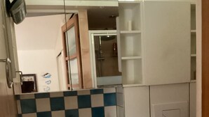 Um banheiro com pia branca, espelho e painel de azulejos quadriculado azul e branco.