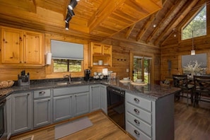 Enjoy cooking in this well-equipped kitchen with a central island, sink, stove, and ample counter space.