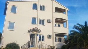 Un edificio a più piani con una piscina di fronte.