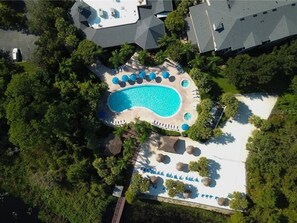 An aerial view of a resort with a swimming pool surrounded by lounge chairs and umbrellas, set in a lush green environment. - Bahama Bay Resort and Spa (801) in Central Florida (Davenport)