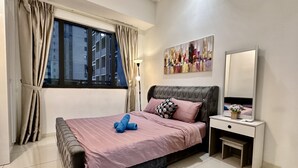 A bedroom with a bed, a nightstand, a mirror, and a window with curtains. - Homey Family Gateway (Petaling Jaya)
