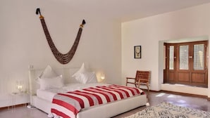 A bedroom with a bed, a hanging decorative item, a chair, and a wooden door with a lattice design. - Luxurious Villa Beldi Chic 20 minutes from Marrakech Medina (Tamesloht)