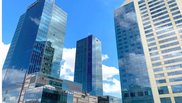 Three modern high-rise buildings with reflective glass facades.