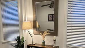 A room with a wooden console table, a mirror, a potted plant, a bookshelf, and a radiator. - Townhouse in Old Fishtown! 10 mins to Center City & Stadiums (Philadelphia)