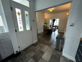 A spacious kitchen with a dining area, a refrigerator, and a tiled floor.